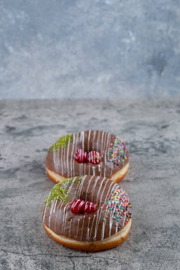 Mermer yüzeyde iki lezzetli çikolata parçacıklı çörek. Yüksek kalite fotoğraf