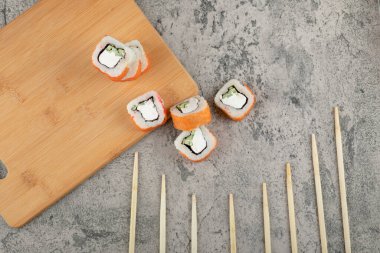 Taş zeminde taze somonla süslenmiş lezzetli suşi ruloları. Yüksek kalite fotoğraf