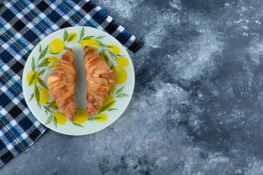 Taze ve lezzetli kruvasanlar taş masaya konmuş. Yüksek kalite fotoğraf
