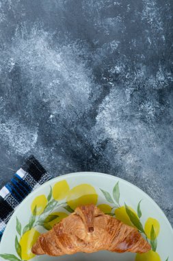 Mermer bir arka plana yerleştirilmiş renkli bir tabak taze kruvasan. Yüksek kalite fotoğraf