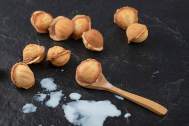 Tahta kaşık cevizli kurabiye ve üzerine siyah süt dökülmüş. Yüksek kalite fotoğraf