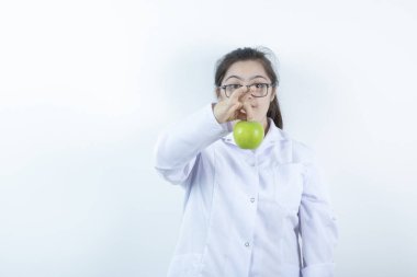 Elinde yeşil elma tutan doktor üniformalı genç bir kız. Yüksek kalite fotoğraf