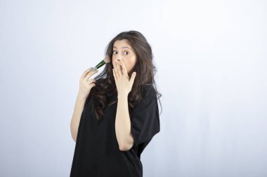 Beyaz arka planda fırçayla makyaj yapan genç modelin portresi. Yüksek kalite fotoğraf