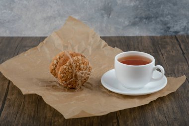 Lezzetli yulaf ezmeli kurabiyeler ve ahşap masada bir fincan çay. Yüksek kalite fotoğraf