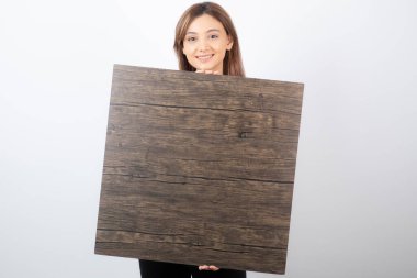 Ahşap arka planda duran genç bir kadın modelin görüntüsü. Yüksek kalite fotoğraf