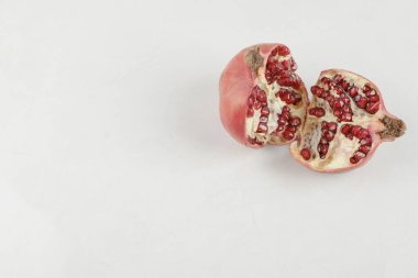Dilimlenmiş taze olgun nar beyaz masaya konur. Yüksek kalite fotoğraf