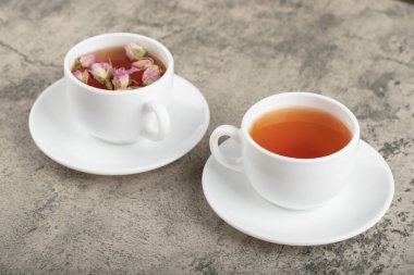 Taş yüzeyinde kurumuş güllerle iki fincan siyah çay. Yüksek kalite fotoğraf