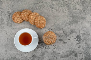Cup of black tea with delicious oatmeal biscuits on stone. High quality photo