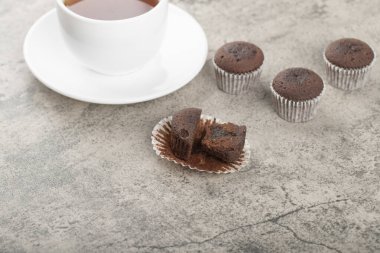Mini chocolate brownies and cup of black tea on stone. High quality photo