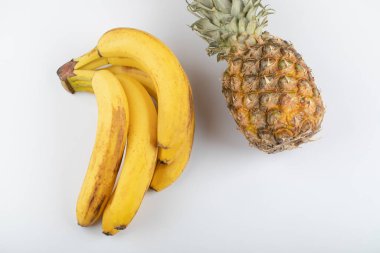 Beyaz arka planda olgun sarı muz ve ananas kümesi. Yüksek kalite fotoğraf