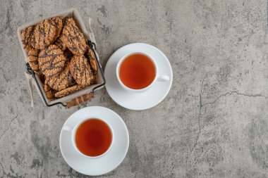 İki fincan siyah çay, içinde bir sepet lezzetli kurabiye ve tohumlar olsun. Yüksek kalite fotoğraf
