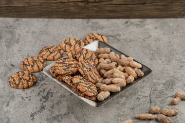 Taş bir arka planda yulaflı kurabiye ve fındıklı güzel bir tabak. Yüksek kalite fotoğraf