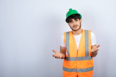Yeşil kasketli genç erkek inşaat işçisi kameraya bakıyor. Yüksek kalite fotoğraf