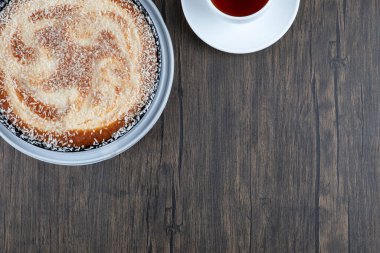 Tahta masaya bir fincan siyah çay ile bir tabak lezzetli turta. Yüksek kalite fotoğraf