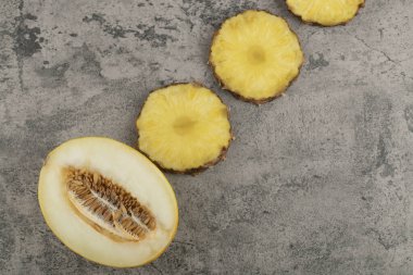 Yarım dilimlenmiş kavun dilimlenmiş, arka planda doğranmış ananas. Yüksek kalite fotoğraf