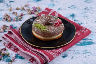 Çikolatalı çörek ve beyaz masada tomurcuklanan güller. Yüksek kalite fotoğraf