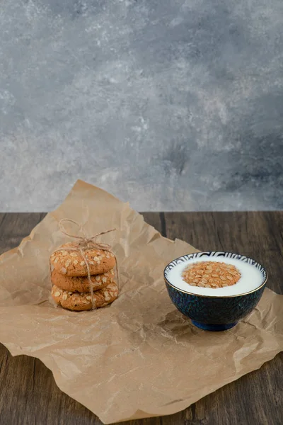 一堆堆美味的燕麦饼干和一碗新鲜牛奶在木制表面 高质量的照片 — 图库照片