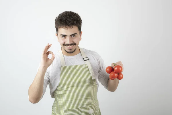 Leende Kille Som Håller Färska Tomater Och Gester Högkvalitativt Foto — Stockfoto