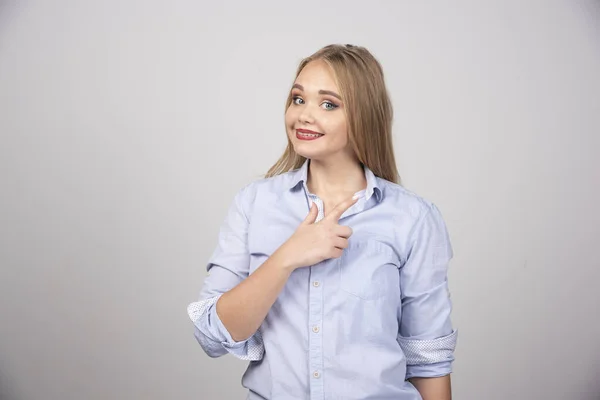 Blonde Frau Steht Und Zeigt Mit Dem Finger Zur Seite — Stockfoto