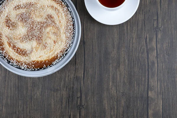 Tahta masaya bir fincan siyah çay ile bir tabak lezzetli turta. Yüksek kalite fotoğraf