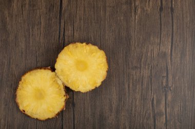 Tahta bir masanın üzerine iki taze olgun ananas dilimi. Yüksek kalite fotoğraf