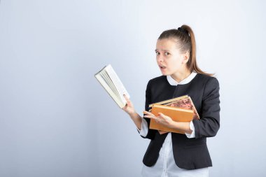 Beyaz arka plan üzerine kitap okuyan bir kız öğrencinin resmi. Yüksek kalite fotoğraf