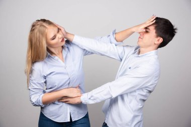 Gri arka planda izole bir şekilde kavga eden iki kızgın insanın portresi. - Evet. Yüksek kalite fotoğraf