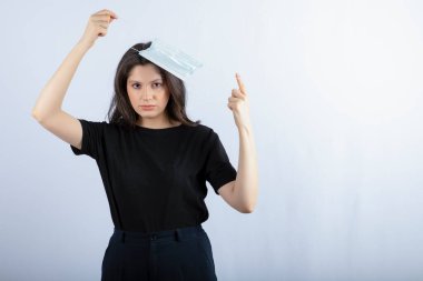 Kafasına tıbbi maske takmış güzel esmer kız. Yüksek kalite fotoğraf