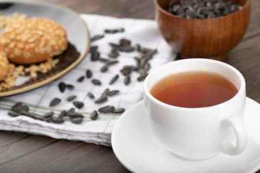 Tahta bir masaya yerleştirilmiş beyaz fincanlı çok tahıllı kurabiyeler. Yüksek kalite fotoğraf