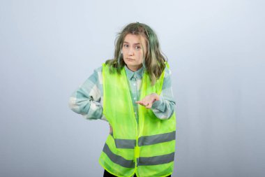 Beyaz duvarın üzerinde duran ve poz veren üniformalı kadın mimarın portresi. Yüksek kalite fotoğraf