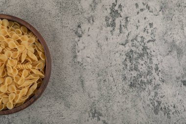 Ahşap bir kase pişmemiş organik makarna. Yüksek kalite fotoğraf