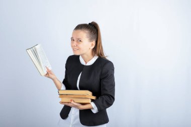 Beyaz arka plan üzerine kitap okuyan bir kız öğrencinin resmi. Yüksek kalite fotoğraf