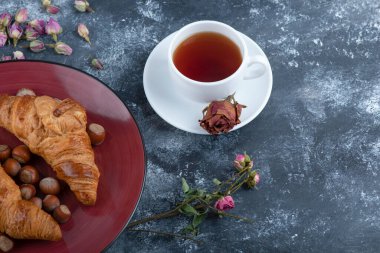 Fındıklı kruvasan tabağı ve mermer üzerine siyah çay. Yüksek kalite fotoğraf