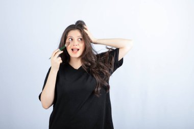 Beyaz arka planda fırçayla allık süren genç ve güzel bir model resmi. Yüksek kalite fotoğraf