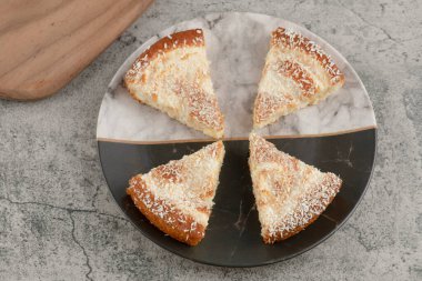 Tahtanın etrafına hindistan cevizi parçacıkları serpiştirilmiş lezzetli kek dilimleri. Yüksek kalite fotoğraf