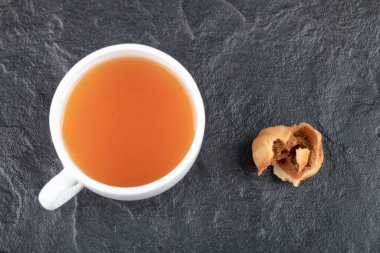 Ceviz şeklinde kurabiyeler ve siyah arka planda bir fincan sıcak çay. Yüksek kalite fotoğraf