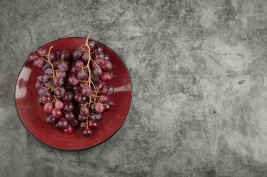Mermer yüzeyine yerleştirilmiş taze üzüm tabağı. Yüksek kalite fotoğraf