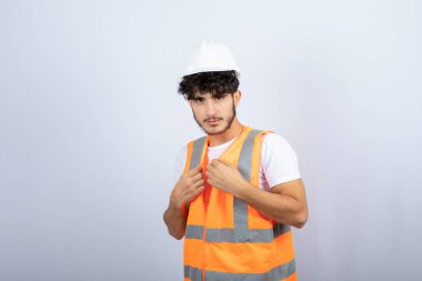 Beyaz duvarın üzerinde duran yakışıklı üniformalı genç adam. Yüksek kalite fotoğraf