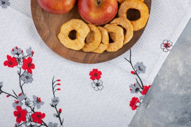 Kurumuş elma halkaları ve beyaz masa örtüsü üzerinde kırmızı elma tabağı. Yüksek kalite fotoğraf