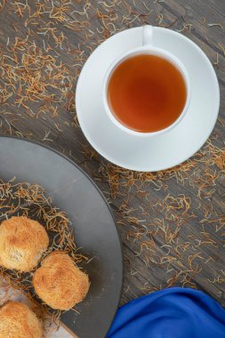 Bir tabak tatlı yuva pastası ve ahşap masada bir fincan çay. Yüksek kalite fotoğraf