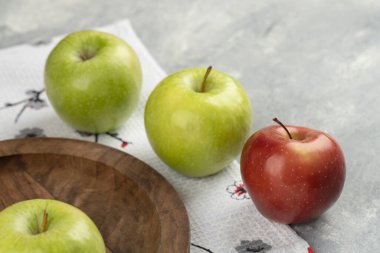 Ahşap tabağın etrafına kırmızı ve yeşil taze elma yerleştirildi. Yüksek kalite fotoğraf