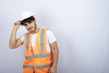 Beyaz duvarın üzerinde duran yakışıklı üniformalı genç adam. Yüksek kalite fotoğraf