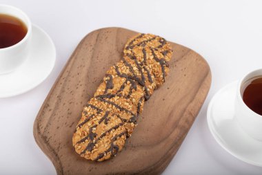 Beyaz masaya çok tahıllı kurabiyeler konmuş beyaz çay fincanı. Yüksek kalite fotoğraf