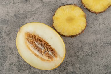 Yarım dilimlenmiş kavun dilimlenmiş, arka planda doğranmış ananas. Yüksek kalite fotoğraf