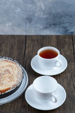 Tahta masaya bir fincan siyah çay ile bir tabak lezzetli turta. Yüksek kalite fotoğraf