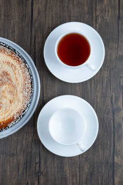 Tahta masaya bir fincan siyah çay ile bir tabak lezzetli turta. Yüksek kalite fotoğraf