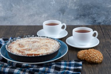 Tahta masaya konmuş turta ve çayla yerleştirilmiş tahıllı yulaf ezmeli kurabiyeler. Yüksek kalite fotoğraf