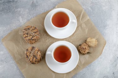 Tohumlu lezzetli bisküviler ve mermer arka planda bir fincan çayla çikolatalı. Yüksek kalite fotoğraf