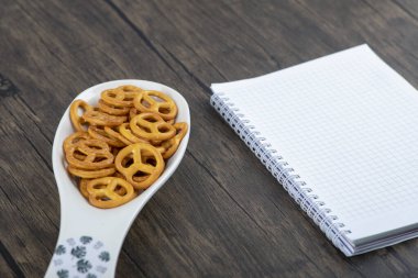 Tahta masaya yerleştirilmiş küçük krakerlerle dolu beyaz kaşık. Yüksek kalite fotoğraf