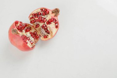 Dilimlenmiş taze olgun nar beyaz masaya konur. Yüksek kalite fotoğraf